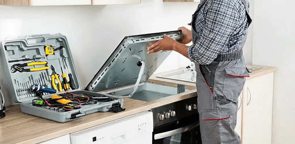 Handyman repairing a cooktop and checking wiring connections in Dallas, TX