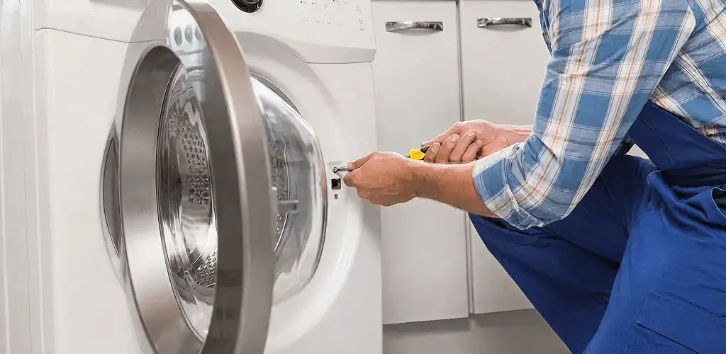 Handyman repairing a clothes dryer and checking electrical connections in Dallas, TX