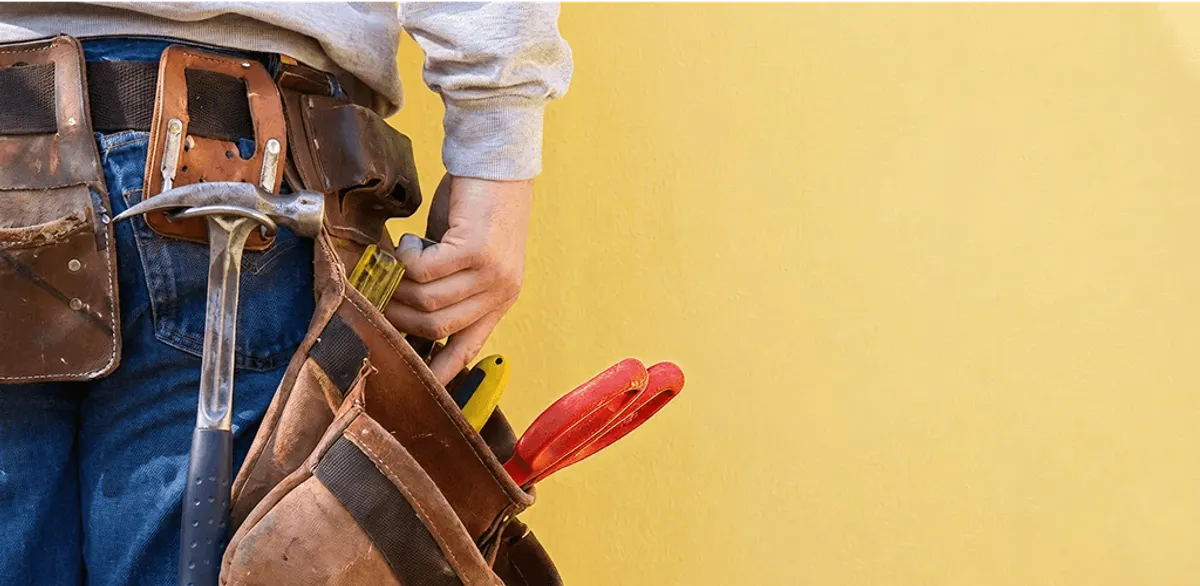 Handyman with tool belt ready for home repairs and maintenance in Dallas, TX