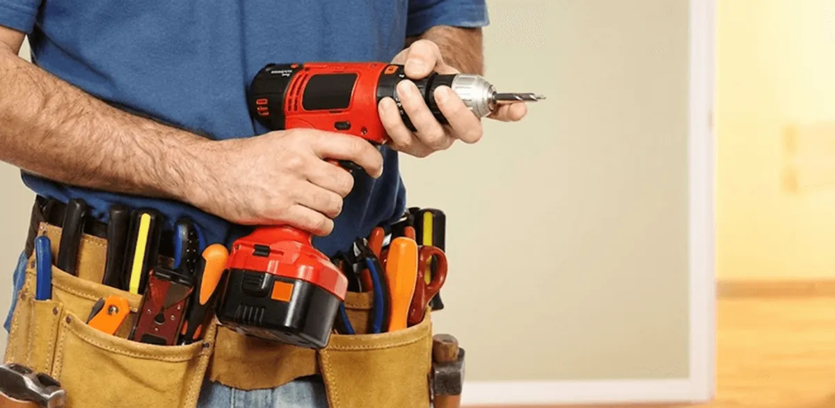 Handyman holding a power drill for home repairs and installations in Dallas, TX