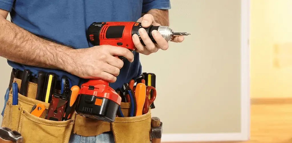 Handyman holding a power drill for home repairs and installations in Dallas, TX