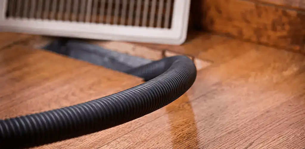Air duct cleaning hose inserted into a floor vent for ductwork cleaning in Dallas, TX